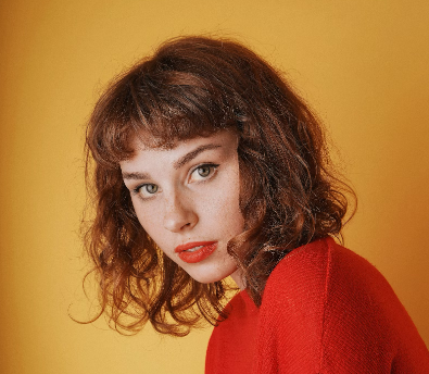 Woman with curly red hair in red top
